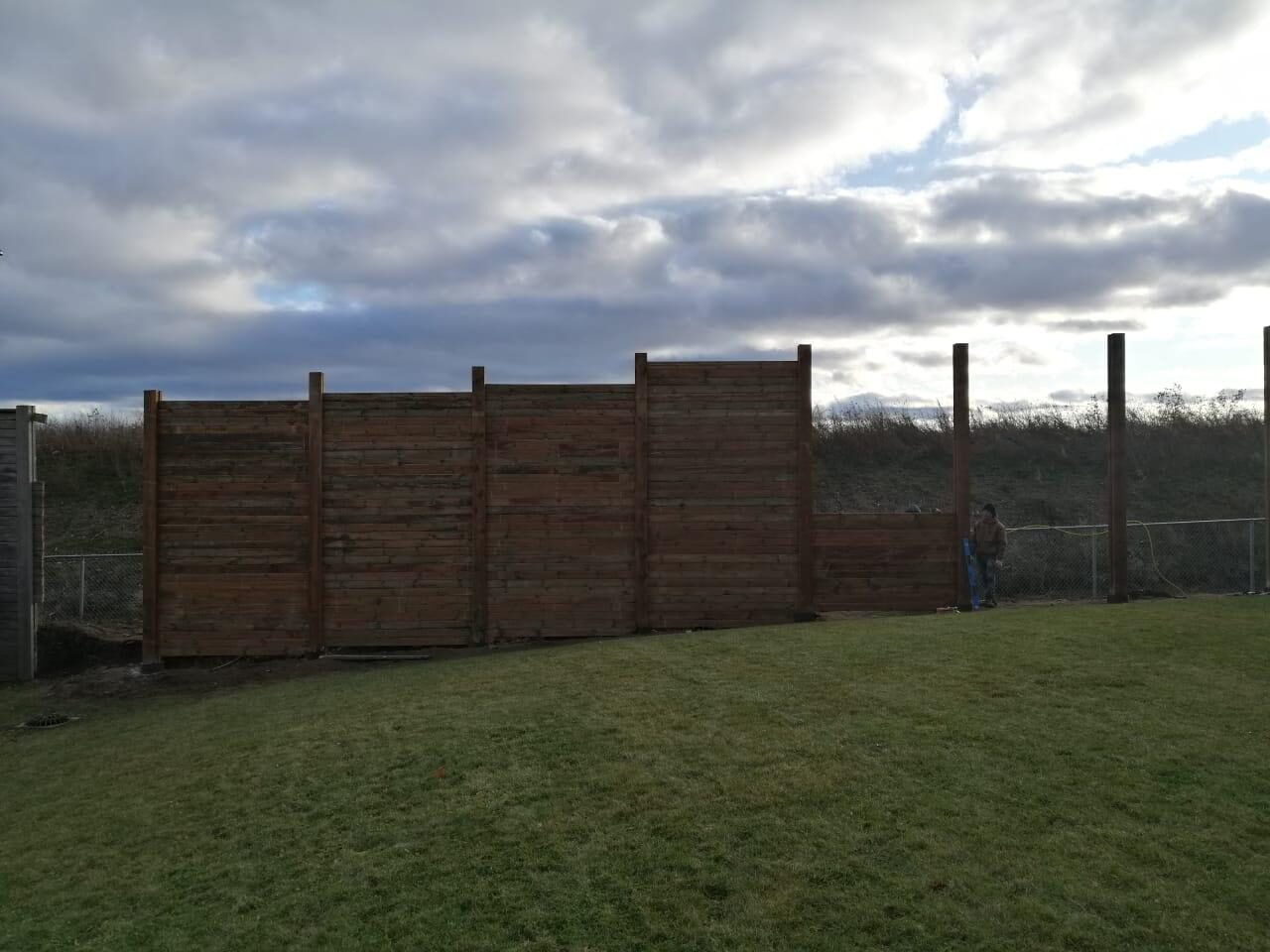 Crew setting pressure-treated fence posts during a wood fence installation in Toronto, ON