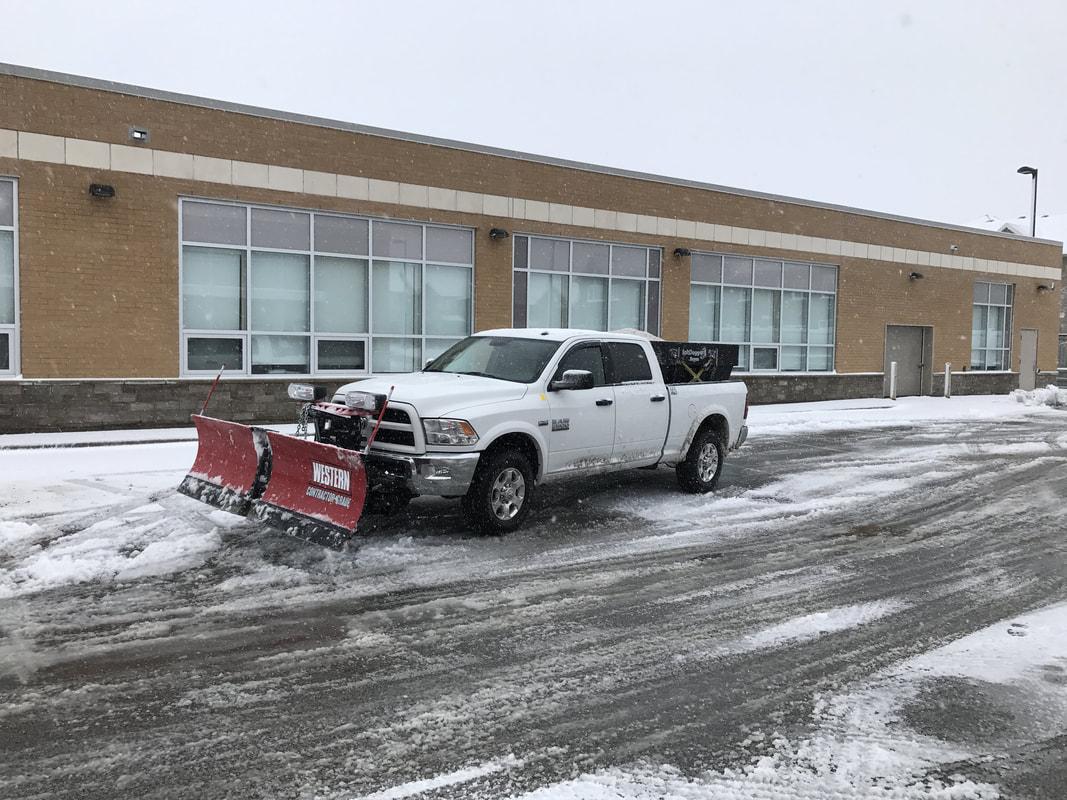 Plow truck servicing commercial property entrance